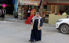 Palestinian woman Naela Abu Jibba, who started a women-only taxi service in Gaza Strip, walks towards her vehicle at Beach refugee camp in Gaza City on November 17, 2020. 