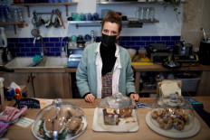 Laure, manager of the vegetarian cafe Yumi, wearing a protective face mask, poses behind the bar counter inside the coffee shop in Paris during the second national lockdown as the coronavirus disease (COVID-19) outbreak continues in France, on November 19, 2020. 