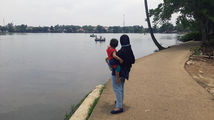Placid water: A visitor and her child enjoy the scenic view of Situ Cilodong. 