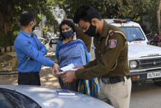 A policeman fines a commuter for not wearing facemask as a preventive measure against the Covid-19 coronavirus, while travelling in car in New Delhi on November 22, 2020, as India's coronavirus caseload passed nine million. 