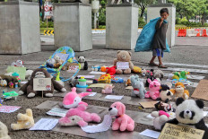 A boy with a bag of scavenged goods looks at toys displayed to commemorate World Children’s Day in Jakarta on Nov. 20. The Extinction Rebellion (XR) group displayed hundreds of toys to represent Indonesian children and urged the government to do more to protect them. JP/Seto Wardhana
