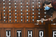 A woman checks catalogues of books at the National Library of India as it reopened for members after more than eight months of shutdown due to the Covid-19 coronavirus pandemic, in Kolkata on November 23, 2020.