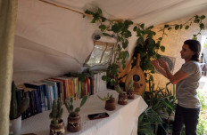 Displaced Syrian, Wissam Diab, 19, is pictured at his new home, a tent surrounded by luscious plants, which recreates his childhood home, in the town of Atme in Syria's northwestern Idlib province on November 19, 2020. 
