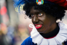 A woman dressed as Zwarte Piet (Black Piet) takes part in the arrival of Sinterklaas (Saint Nicolas) during the traditional move-in 'Intocht Sinterklaas' event in Groningen, Netherlands, on November16, 2013. 