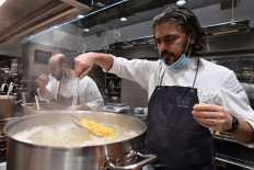 Michelin-starred Del Cambio restaurant, chef Matteo Baronetto (right) and his assistant Vittorio di Palma prepare pasta with meat sauce on November 17, 2020 in Turin, a dish that will be distributed to associations which help people in need during the COVID-19 pandemic caused by the novel coronavirus. 
