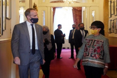 British Foreign Secretary Dominic Raab (left) walks with Indonesian Foreign Minister Retno L.P. Marsudi on Oct. 14, 2020 at Lancaster House, London, during the latter's visit to discuss international cooperation on COVID-19 vaccines.