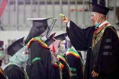 A Jakarta State University (UNJ) rector interacts virtually with a graduate during a graduation ceremony in Jakarta on Nov. 21. The ceremony celebrated 2,946 graduates and used technology to replace physical attendance amid the COVID-19 pandemic. JP/Seto Wardhana