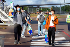 This handout picture taken on November 30, 2020 and released by Charles Darwin University shows foreign students disembarking from an international flight at Darwin Airport in Darwin. - International students have arrived in Australia for the first time since the country shut its borders to curb coronavirus in March, with a charter flight touching down in Darwin on November 30. 