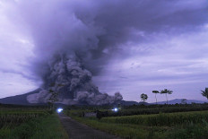 A plume of volcanic matter from Mount Semeru drifts down its slopes in Pronojiwo, Lumajang, East Java, on Dec. 1, 2020.