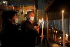 Visitors light candles in the Church of the Nativity, amid the coronavirus disease (COVID-19) outbreak, in Bethlehem in the Israeli-occupied West Bank on November 26, 2020. 