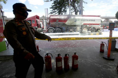 A police officer guards a Pertamina fuel station on Jl. MT Haryono in South Jakarta after a fuel tanker caught fire on Dec. 1, 2020.