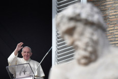 Pope Francis waves as he arrives to address worshipers from the window of the apostolic palace overlooking St. Peter's Square during the weekly Angelus prayer on Sunday in the Vatican.
