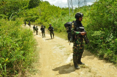 Soldiers patrol through a remote village in the Central Sulawesi regency of Sigi in this file photo from April 2020. The military and police are hunting down members of the East Indonesia Mujahidin (MIT) terrorist group held responsible for the murder of local residents.