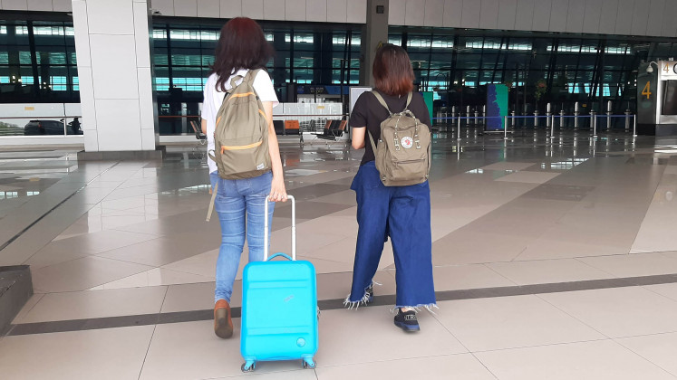 Clear to fly: Faras and her daughter, Tiara, walk into the airport to catch a flight to Bali, after getting nonreactive results from a rapid antibody test. 