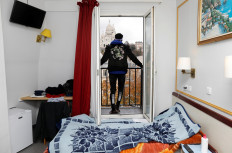 Asylum-seeker Ibrahim looks at the Sacre Coeur Cathedral from his room at the Hotel Avenir Montmartre in Paris, France, on December 2, 2020. 