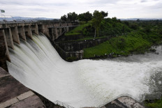 People watch the Rawal Dam after the spillway opened due to heavy monsoon rains in Islamabad on August 31, 2020.