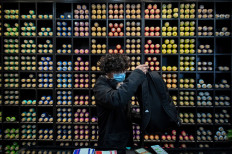 A graffiti artist, in a store where supplies are sold to make graffiti, prepares his bag with spray paint cans in Wuhan on November 22, 2020. 