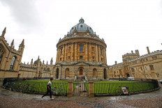  A man walks in front of the buildings of Oxford University, amid the spread of COVID-19 in Oxford, Britain, Oct.6 2020. 