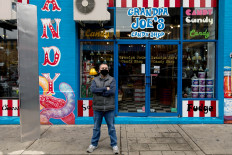 Christopher Beers, owner of Grandpa Joe's Candy Shop, stands near a monolith outside his store in Pittsburgh, Pennsylvania, United States, on December 4, 2020. 