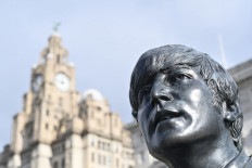 In this file photo taken on October 7, 2020 a statue of John Lennon and members of the Beatles stands in central Liverpool, northwest England. 