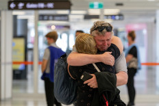 A passenger is greeted by a loved one after arriving from Sydney at Perth Domestic Airport following the state of Western Australia's extended border closure due to the coronavirus disease (COVID-19) pandemic, in Perth, Australia, on December 8, 2020. 