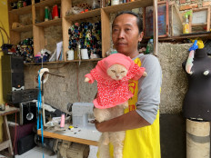 Fredi Lugina Priadi, 39, holds his cat wearing a cosplay costume in Bogor, on the outskirts of Jakarta, Indonesia, November 26, 2020. Reuters/Yuddy Cahya Budiman