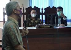 Tri Teguh Pujianto, a 31-year-old former police brigadier who was fired in 2018, sit with his lawyer Maruf Bajammal while hearing a witness Siswanto, a psychology lecturer from Soegijapranata University, during his trial at a court in Semarang, Central Java province, Indonesia, on Tuesday. 
