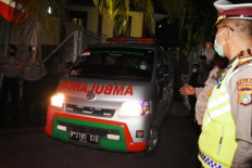 An ambulance carrying the bodies of Islam Defenders Front (FPI) members leaves Kramat Jati Police Hospital in Jakarta on Dec. 8, 2020, the day after they were killed in a  police shootout on the Jakarta-Cikampek toll road.