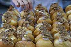 A gold leaf is added atop a date-flavoured 'Abu Dhabi' doughnut created for the Jewish holiday of Hanukkah and in honor to the new diplomatic relations between Israel and the United Arab Emirates, at Kadosh pastry shop in Jerusalem on December 7, 2020. 