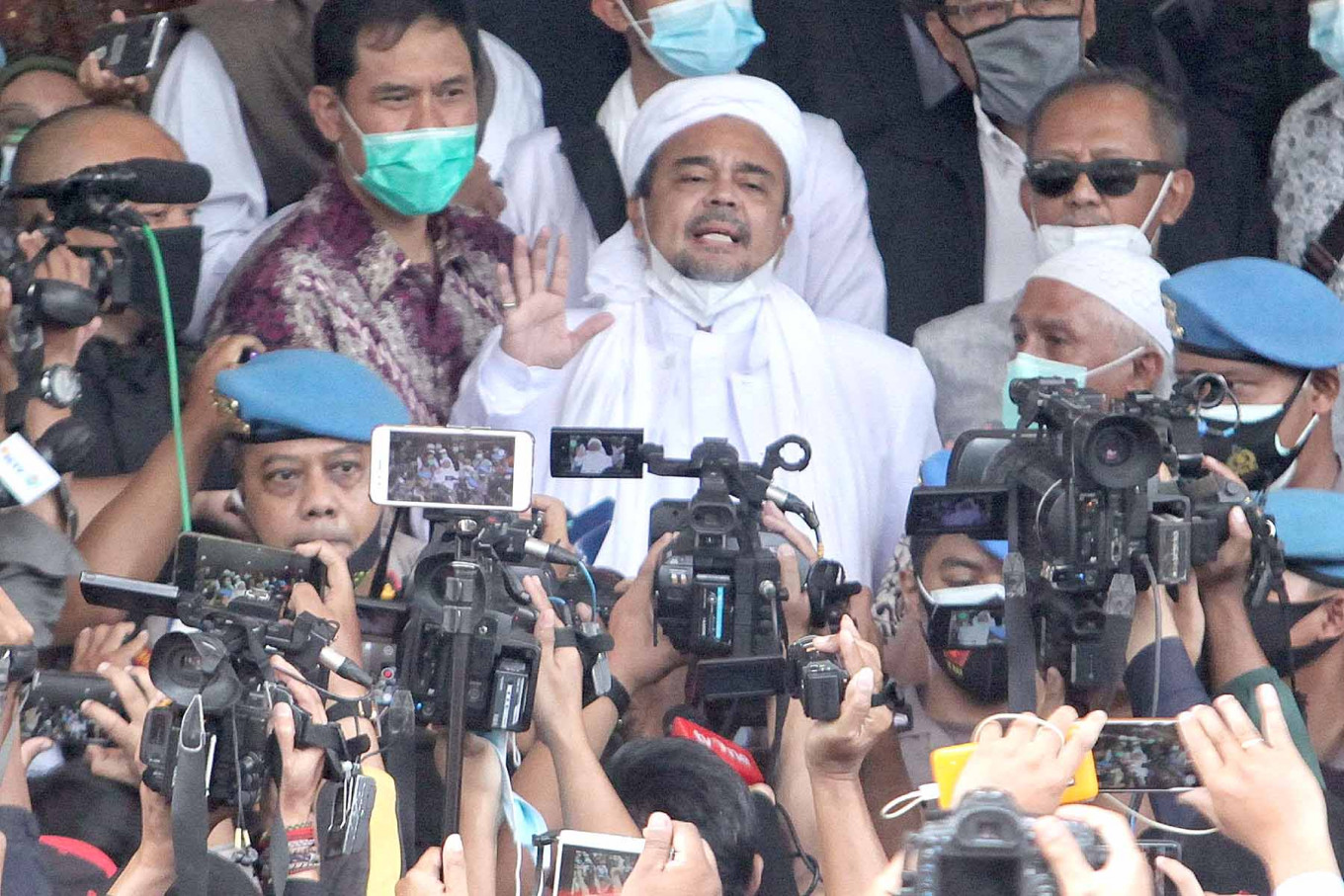 Islam Defenders Front (FPI) leader Rizieq Shihab arrives at the Jakarta Police headquarters in Jakarta on Saturday. Rizieq, along with five other FPI members, were named suspects for holding crowd-pulling events at his house and at the group’s headquarters in Petamburan, Central Jakarta. 