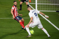 Atletico Madrid's Spanish midfielder Koke (left) vies with Real Madrid's French forward Karim Benzema during the Spanish league soccer match between Real Madrid CF and Club Atletico de Madrid at the Alfredo di Stefano stadium in Madrid on Saturday. 

