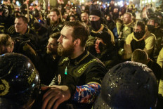 Members of the Proud Boys pray for a member who was stabbed during a protest on Saturday in Washington, DC. Thousands of protesters who refuse to accept that President-elect Joe Biden won the election are rallying ahead of the electoral college vote to make Trump's 306-to-232 loss official. Stephanie Keith/Getty Images/AFP 