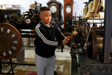 Clocks collector Pham Van Thuoc adjusts an old church clock from Europe at his home in Thai Binh province, Vietnam, on December 6, 2020. 