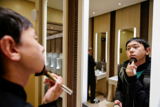 Liu Yuxuan, 22, a student, puts on his make-up at a restroom in a shopping mall in Shanghai, China, on December 3, 2020. 