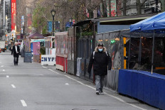 People walk past outside dining areas during the coronavirus disease (COVID-19) pandemic in the Manhattan borough of New York City, New York, U.S., December 15, 2020. 