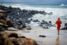 A lifeguard views massive beach erosion in the wake of cyclonic conditions at Byron Bay Main Beach on December 15, 2020, after wild weather lashed Australia's Northern New South Wales and South East Queensland with heavy rain, strong winds and king tides.