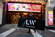 An employee removes a sign for guests as the last day of performances of the pantomime 'Pantoland' that takes place at the Palladium theatre, ahead of new restrictions amid the spread of the coronavirus disease (COVID-19), in London, Britain, on December 15, 2020. 