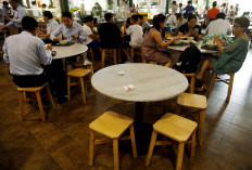 People leave packets of tissue paper to reserve their seats as they queue for food at Lau Pa Sat food center in Singapore on August 1, 2016. 