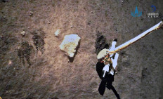 This picture taken on December 2, 2020 and released on December 3, 2020 by the China National Space Administration (CNSA) via CNS shows the Chang'e-5 lunar probe gathering samples on the moon. 