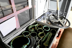 A picture taken on December 14, 2020 shows archeological pieces of the Iron Age and the Bronze Age past a metal detector, part of 27.500 archeological items in Metz, eastern France, seized by customs officers and which were held by a man from France northeastern region Lorraine who tried to sell them in Belgium.