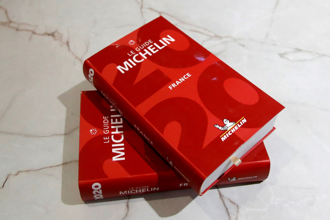 copies of the 2020 france michelin guide on a white marble countertop