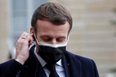French President Emmanuel Macron, wearing a protective face mask, adjusts his headphone as he talks to the media with Portugal's Prime Minister Antonio Costa (not seen) before a meeting at the Elysee Palace in Paris, France, Dec.16, 2020.