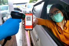 Phone wallet: An employee serves a buyer paying with the ShopeePay online payment app at a McDonald’s drive-through in Salemba, Jakarta, on Tuesday. 
