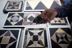 Israeli archaeologist Assaf Avraham displays a stone, that according to archaeologists, was used for flooring in Jerusalem's Roman-era Jewish temple, in Jerusalem on November 16, 2020. 