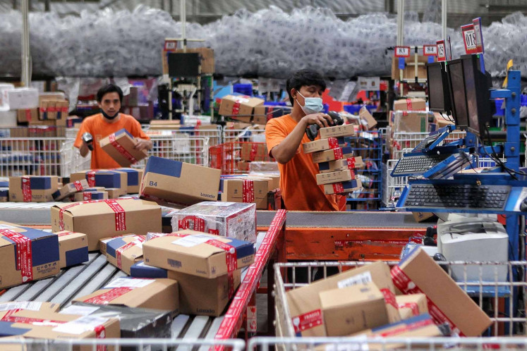 Employees sort out goods at a Lazada warehouse in Cimanggis, West Java, on Dec. 17. During Lazada’s three-day national online shopping (Garbolnas) held on Dec. 12-14, the online shop saw a 100 percent increase in sales compared with 2019. Bank Indonesia (BI) recorded Rp 180.74 trillion (US$ 12.8 billion) in e-commerce transactions as of September, lower than the 2019 figure of Rp 201 trillion. JP/Seto Wardhana