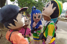 Children wearing costumes of various cartoon characters work as street singers to collect money from passersby in Cibinong, Bogor regency, West Java, on Dec. 14. They said they went out busking after attending their online classes. JP/P.J. Leo