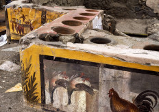 This picture released on December 26, 2020 by the Pompei Press Office shows a thermopolium, a sort of street "fast-food" counter in ancient Rome, that has been unearthed in Pompei, decorated with polychrome motifs and in an exceptional state of preservation. The counter frozen by volcanic ash had been partly unearthed in 2019 but the work was extended to best preserve the entire site, located at the crossroads of rue des Noces d'Argent and rue des Balcons.