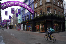 A cyclist rides down a near-deserted Carnaby Street in London on Boxing Day, December 26, 2020, as Londoners continue to live under Tier 4 lockdown restrictions. - Fears over new strains and surging coronavirus infections in general across Europe have severely dampened the mood over the holiday season. 
