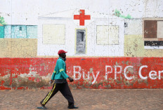 A man, not wearing a face mask, walks beneath a mural depicting a hospital, amid the coronavirus disease (COVID-19) outbreak, in Soweto, South Africa, Dec. 28, 2020.