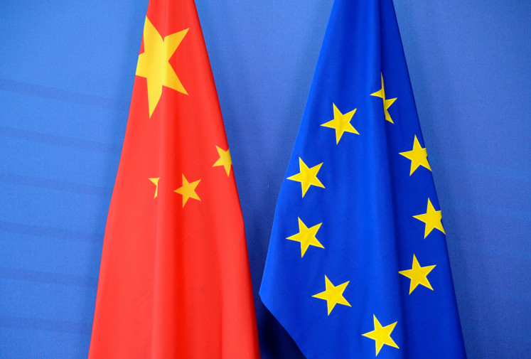 A Chinese flag (left) is draped beside the European Union (EU) flag during a EU-China Summit at European Union Commission headquarters in Brussels.